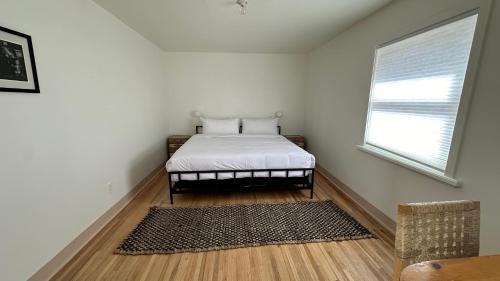 a bedroom with a bed with a window and a rug at The Parador in Santa Fe