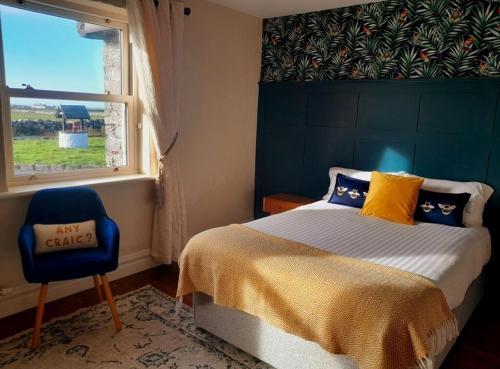 ein Schlafzimmer mit einem Bett, einem Stuhl und einem Fenster in der Unterkunft Cliffs View Self Catering @ Limestone Lodge in Doolin