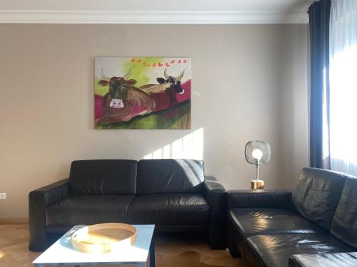 a living room with a couch and a painting on the wall at S-VILLA Apartments im Schwarzwald in Schiltach