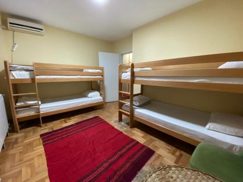 a room with two bunk beds and a red rug at Hakuna Matata in Skopje