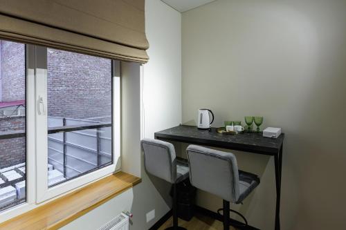 a room with a desk with two chairs and a window at Discovery Garden apartments in Khmelʼnytsʼkyy