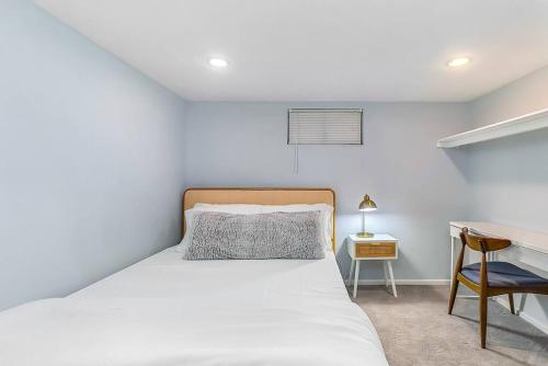 a bedroom with a white bed and a desk at Skyline Blue House in Greenwood in Seattle