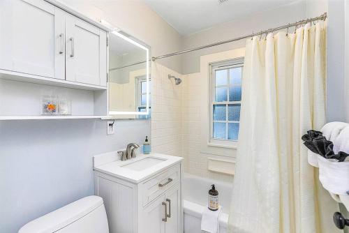 een witte badkamer met een wastafel en een toilet bij Skyline Blue House in Greenwood in Seattle