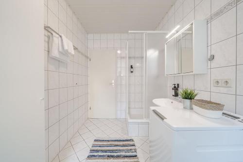 a white bathroom with a sink and a shower at BENVILLE Meißen - WLAN - Smart-TV - Free Parking in Meißen