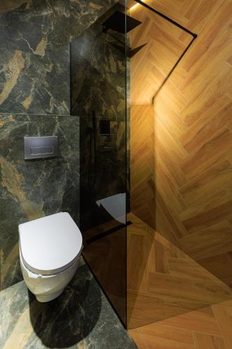 a bathroom with a toilet and a glass wall at Discovery Garden apartments in Khmelʼnytsʼkyy