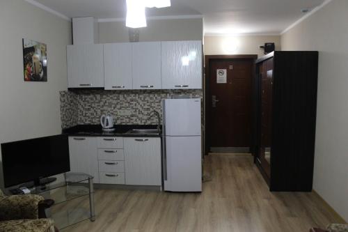 a kitchen with white cabinets and a white refrigerator at Holidays in Panorama Batumi in Batumi