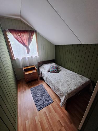 a small bedroom with a bed and a window at Cabaña puerto varas in Llanquihue