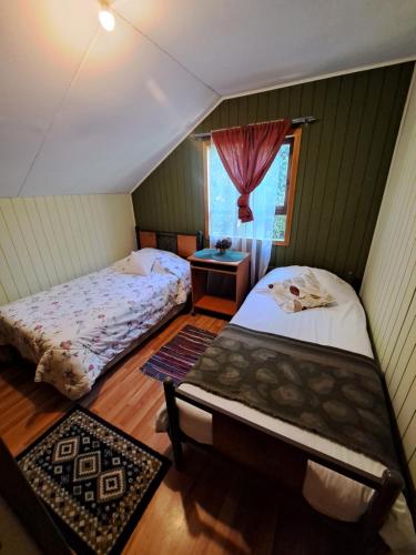 1 dormitorio con 2 camas y ventana en Cabaña puerto varas, en Llanquihue