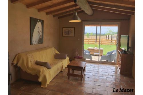 een woonkamer met een bed en een tafel bij Manade de la clapiere-Mas du Plan in Le Cailar