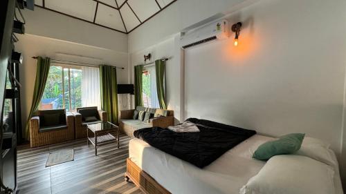 a living room with a bed and a couch and a chair at Garggi Kumarakom Village Homestay in Kumarakom