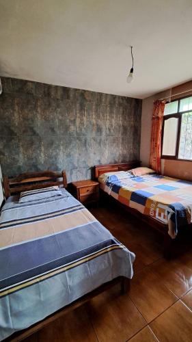 een slaapkamer met 2 bedden en een raam bij Cabañas la monita in Villa Tunari