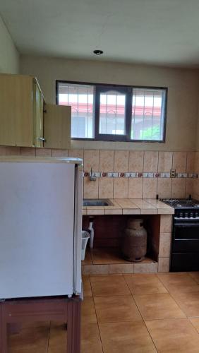 a kitchen with a counter and a refrigerator in it at Cabañas la monita in Villa Tunari