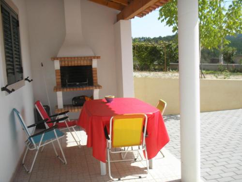 a table and chairs on a patio with a fireplace at Casa do Rio in Figueiró dos Vinhos