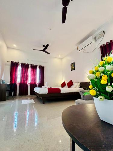 a living room with a bed and a table with flowers at Sai Shreyas Residency, Best Hotel near Bangalore Airport in Bengaluru