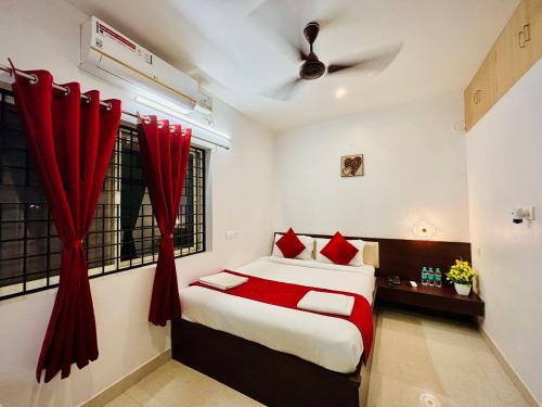 a bedroom with a bed with red curtains at Sai Shreyas Residency, Best Hotel near Bangalore Airport in Bengaluru