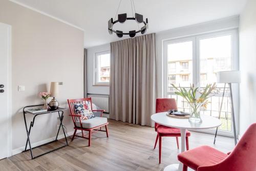 a white living room with a table and chairs at Apartament na Powiślu in Warsaw