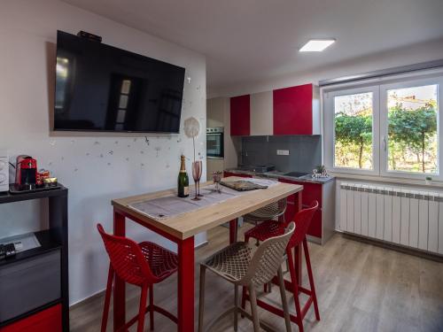 a kitchen with red chairs and a wooden counter top at Brojdi in Labin