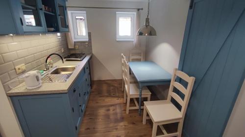 a small kitchen with a sink and a table at Dom Šumiac - prízemie in Šumiac