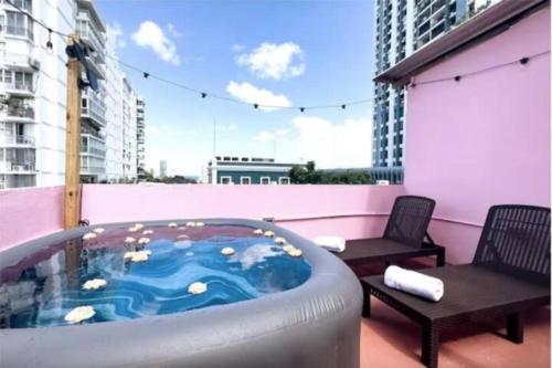 a hot tub on a balcony with two chairs at 610@Miramar in San Juan