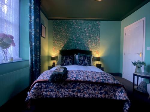 a bedroom with a large bed with blue walls at Number Two Russell House Tavistock Devon in Tavistock