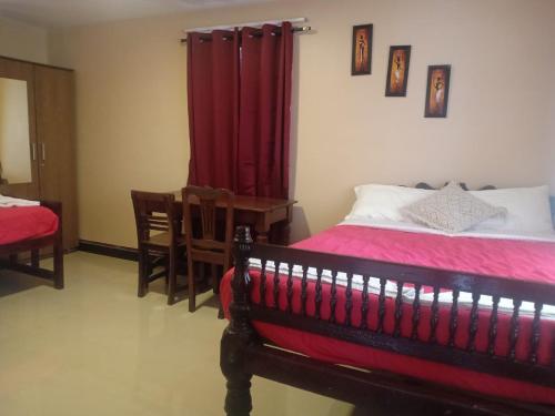 a bedroom with a bed and a red curtain at Silver Spruce 2BHK Entire Floor Kotagiri in Kotagiri
