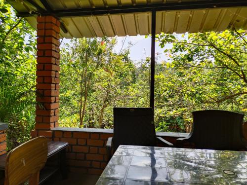 a table and chairs on a patio with trees at Silver Spruce 2BHK Entire Floor Kotagiri in Kotagiri