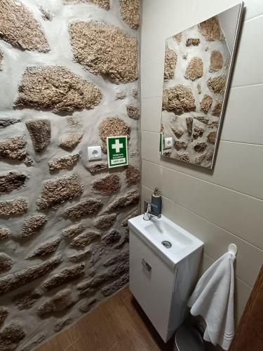 a bathroom with a stone wall and a toilet at Casa dos Avós in Avelal