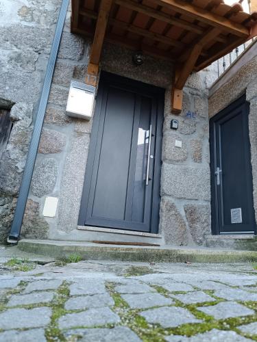 a black door on a stone building at Casa dos Avós in Avelal