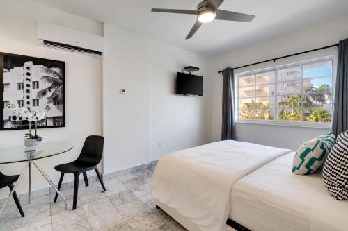 1 dormitorio con cama, mesa y ventana en Best location in SOBE - 2 min to beach & Ocean Dr, en Miami Beach