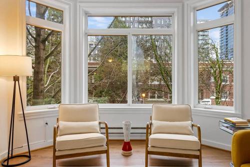 a living room with two chairs and two windows at Belltown's Flower Moon, near The Space Needle in Seattle