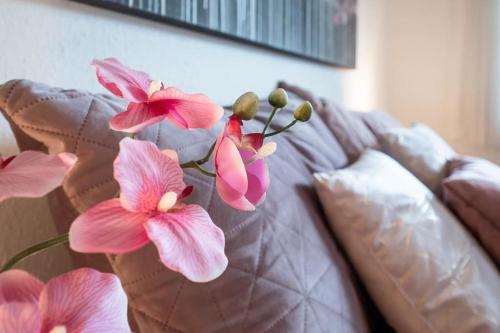 um vaso com flores cor-de-rosa num sofá em Ferienwohnung Julija Riedheim em Hilzingen