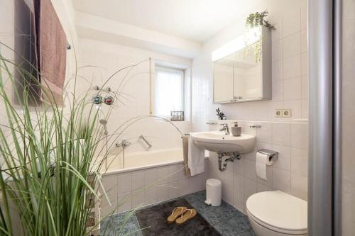 a bathroom with a sink and a toilet and a bath tub at Ferienwohnung Julija Riedheim in Hilzingen