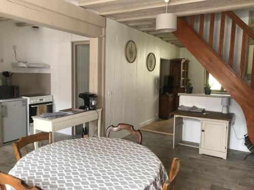 eine Küche mit einem Tisch und Stühlen im Zimmer in der Unterkunft Maison de village cosy avec jardin 