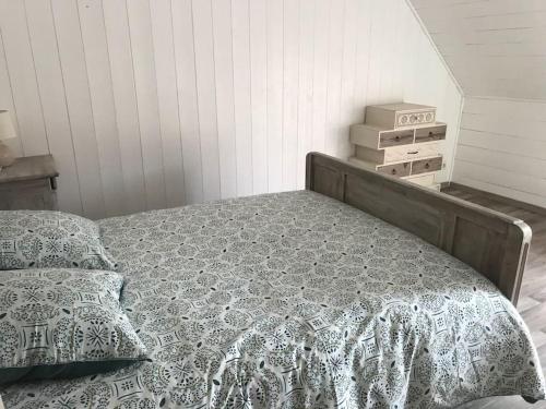 ein Bett mit einer Bettdecke und Kissen im Schlafzimmer in der Unterkunft Maison de village cosy avec jardin 
