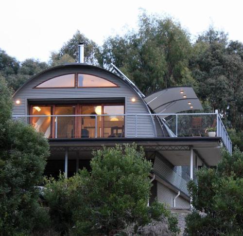 a round house on top of a hill with trees at Cocoon House in Newbury