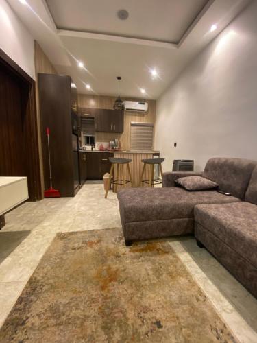 a living room with a couch and a kitchen at LTD GRAND APARTMENTS in Wupa