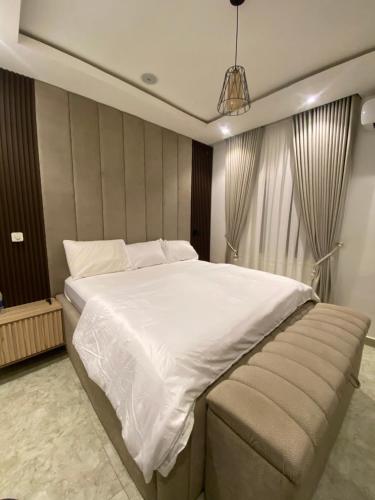 a bedroom with a large white bed and a couch at LTD GRAND APARTMENTS in Wupa