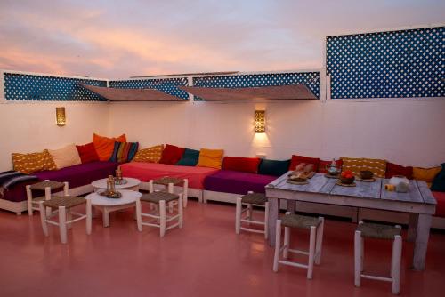 een woonkamer met een bank en tafels en stoelen bij DAR ORY in Essaouira