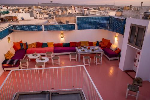 een balkon met banken en een tafel en stoelen bij DAR ORY in Essaouira