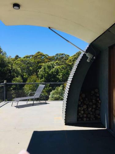 a patio with a fire pit and a chair on a deck at Cocoon House in Newbury