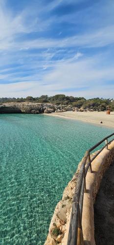 a view of a beach with a fence and the water at Casa Domingos Cales De Mallorca in Calas de Mallorca