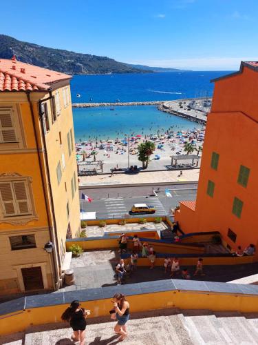 a view of a beach with people in the water at MENTON, centre historique, vue mer in Menton