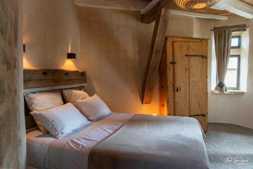 - une chambre avec un lit doté d'une tête de lit en bois et d'une porte dans l'établissement Bodétour, tour charmante pour un séjour insolite, 