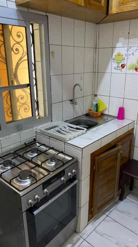 une cuisine avec une cuisinière et un évier dans l'établissement Trierhouse, à Douala