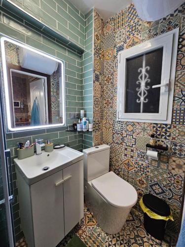 a bathroom with a toilet and a sink and a window at Casa Domingos Cales De Mallorca in Calas de Mallorca