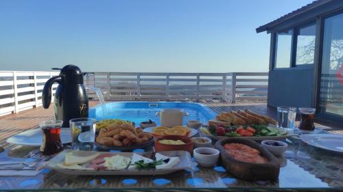 ein Buffet mit Speisen auf einem Tisch neben einem Pool in der Unterkunft corner life bungalow sapanca My green garden turizm konaklama restorant tic ltd şt in Sapanca
