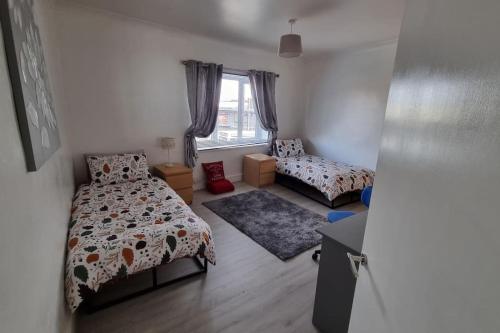 a small bedroom with two beds and a window at Dog-friendly Gosport town house sleeps 8 in Brockhurst