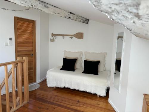 - une chambre avec un lit blanc et des oreillers noirs dans l'établissement Appartement de charme centre Collioure, à Collioure