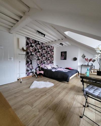 - une chambre avec un lit et un mur orné de fleurs dans l'établissement La panthère rose, à Honfleur