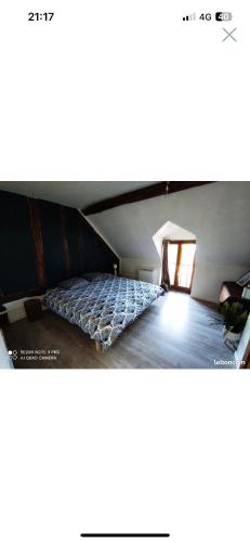ein Zimmer mit einem Bett in der Mitte eines Zimmers in der Unterkunft Gîte l’échappée belle in La Gollotte